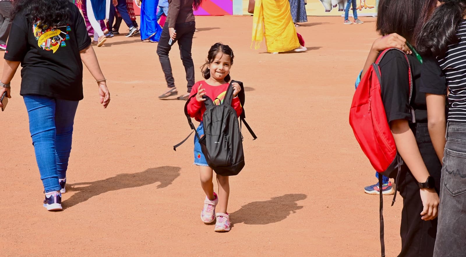 Une fille avec un sac à dos avance sur un chemin, à l'extérieur.