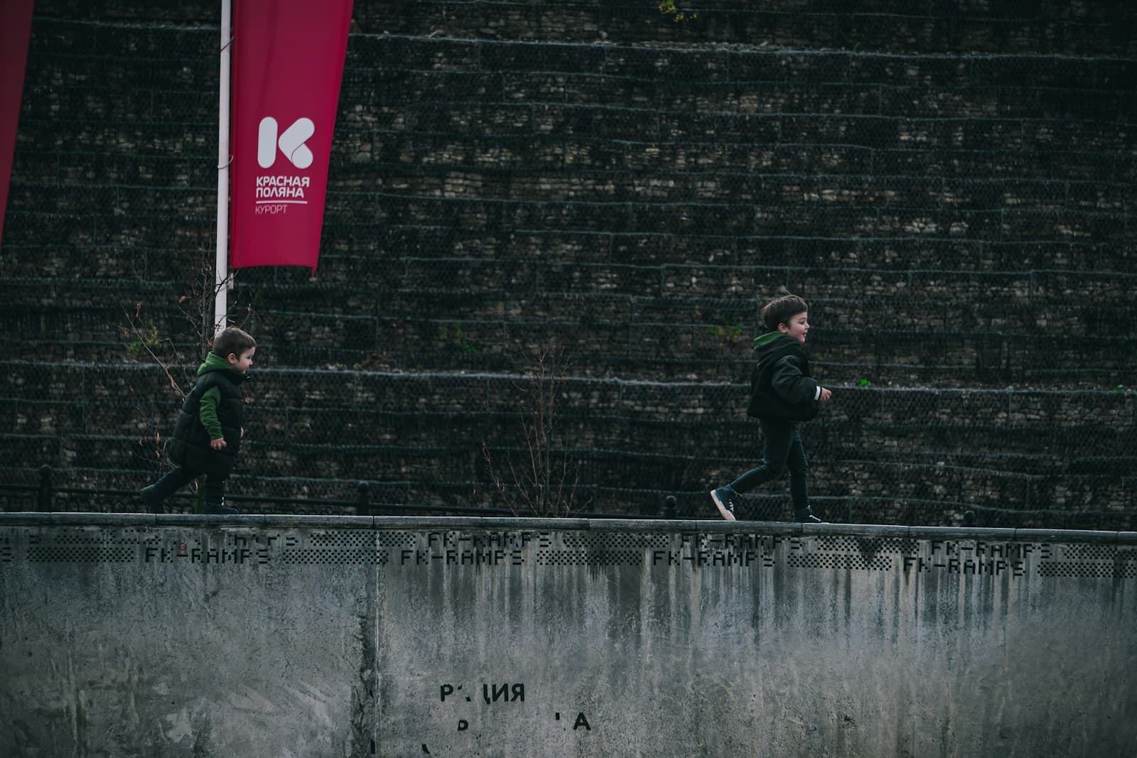 Deux enfants courent côte à côte sur une passerelle.