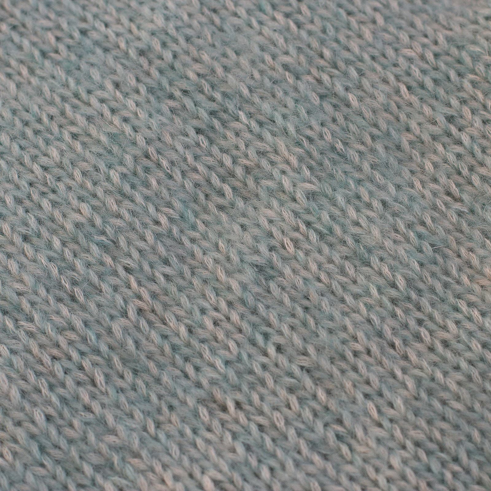 Gros plan sur une maille bleu pâle, dont on distingue chaque boucle.